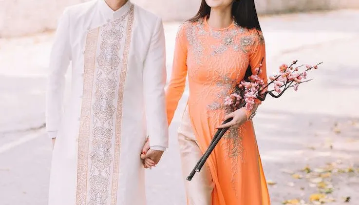 Nhật Tinh Anh, Cao Th&ugrave;y Linh tay trong tay thật chặt đi dạo phố với t&agrave; &aacute;o d&agrave;i họa tiết khỉ xuất hiện tr&ecirc;n t&agrave; &aacute;o d&agrave;i truyền thống của nh&agrave; thiết kế &Aacute;o d&agrave;i Minh Ch&acirc;u, Chiếc &aacute;o d&agrave;i c&aacute;ch điệu đặc sắc.